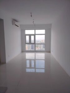 Empty white living room with a glossy tiled floor, large window and city skyline view; ceiling light fixtures hanging from wires.
